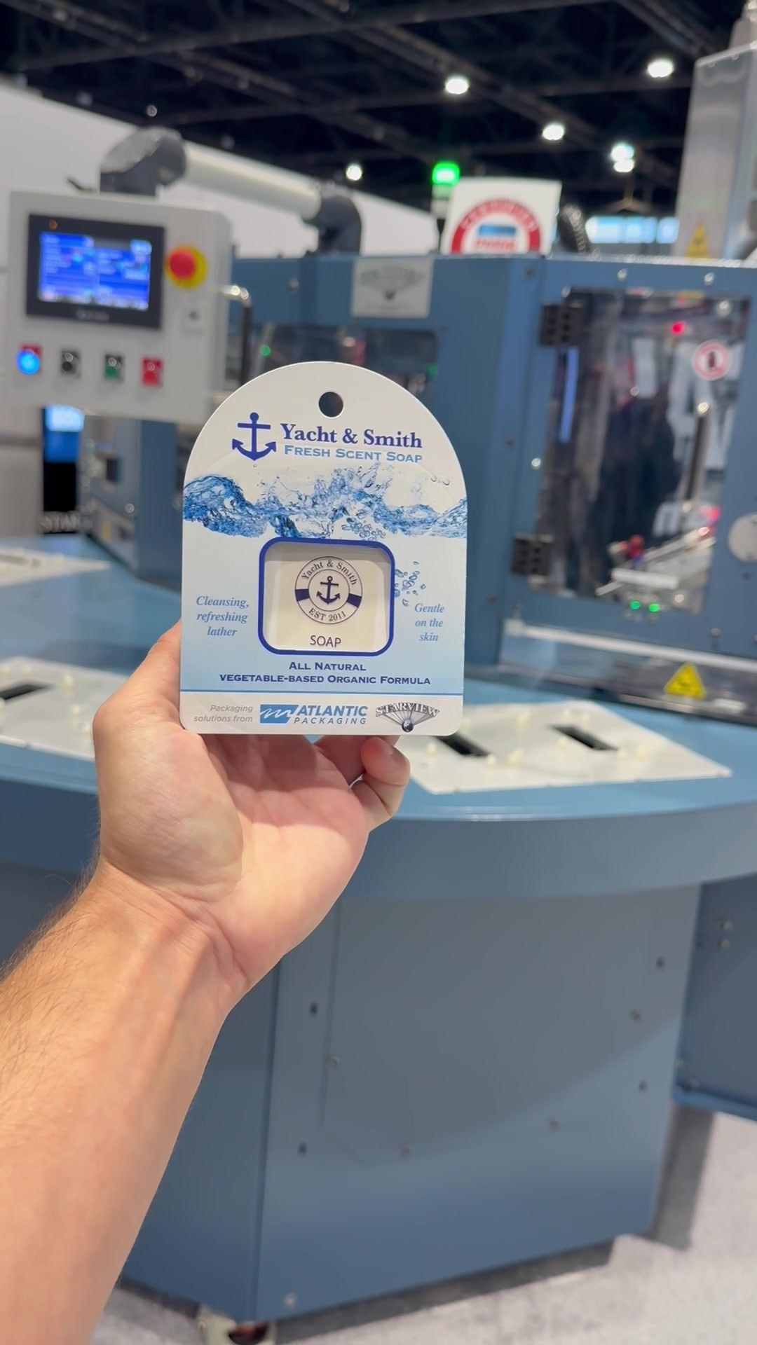 A Paperform pack held up in front of Starview blister sealing equipment